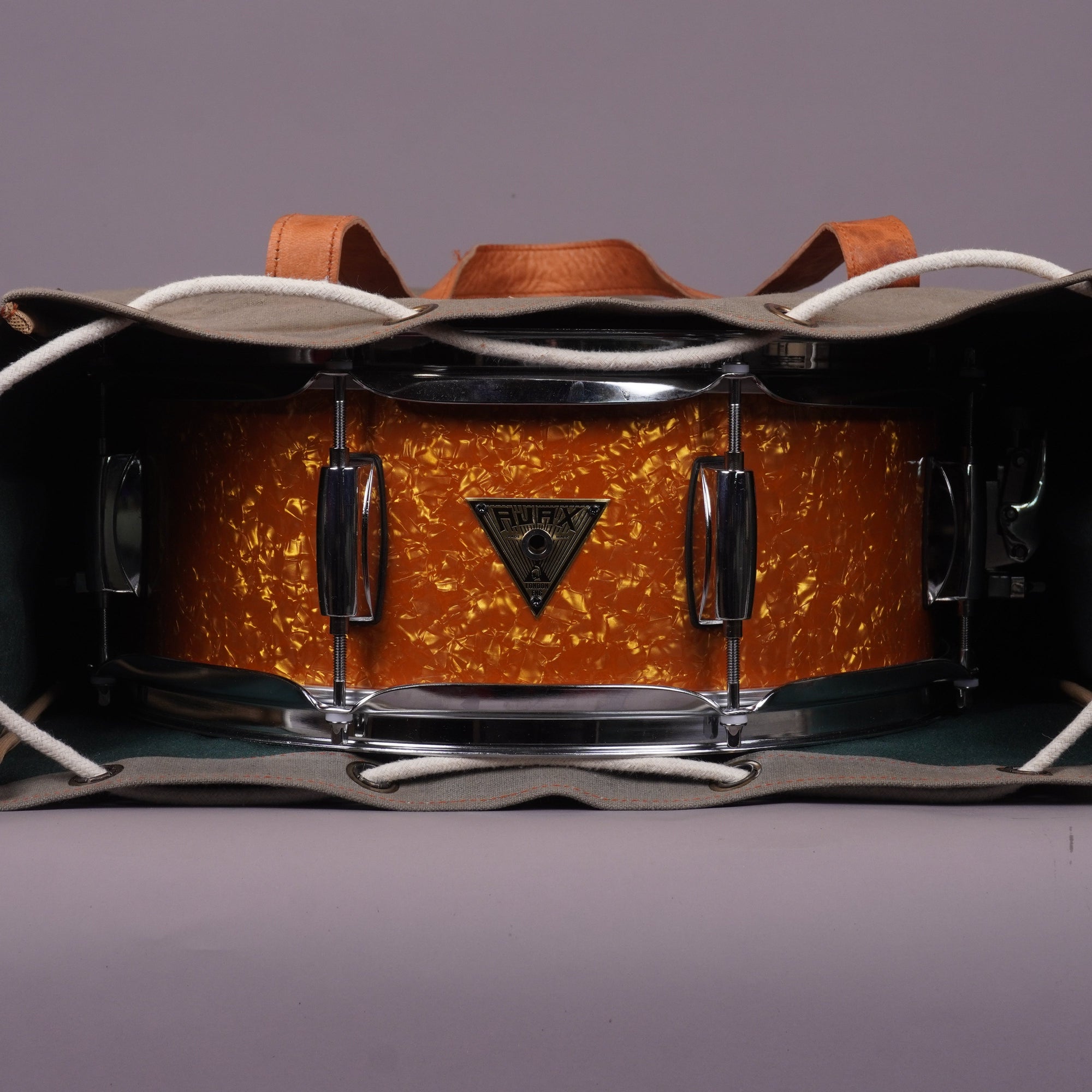 A snare drum in british marmalade finish wraped in a bag