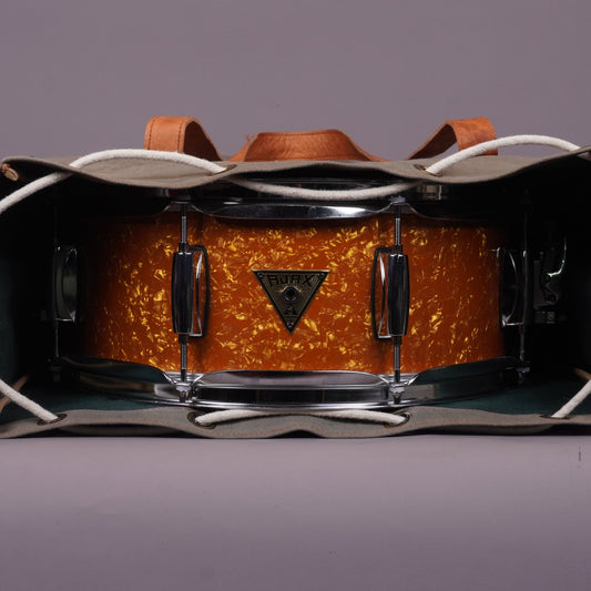 A snare drum in british marmalade finish wraped in a bag