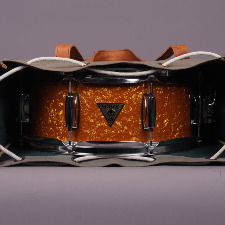 A snare drum in british marmalade finish wraped in a bag