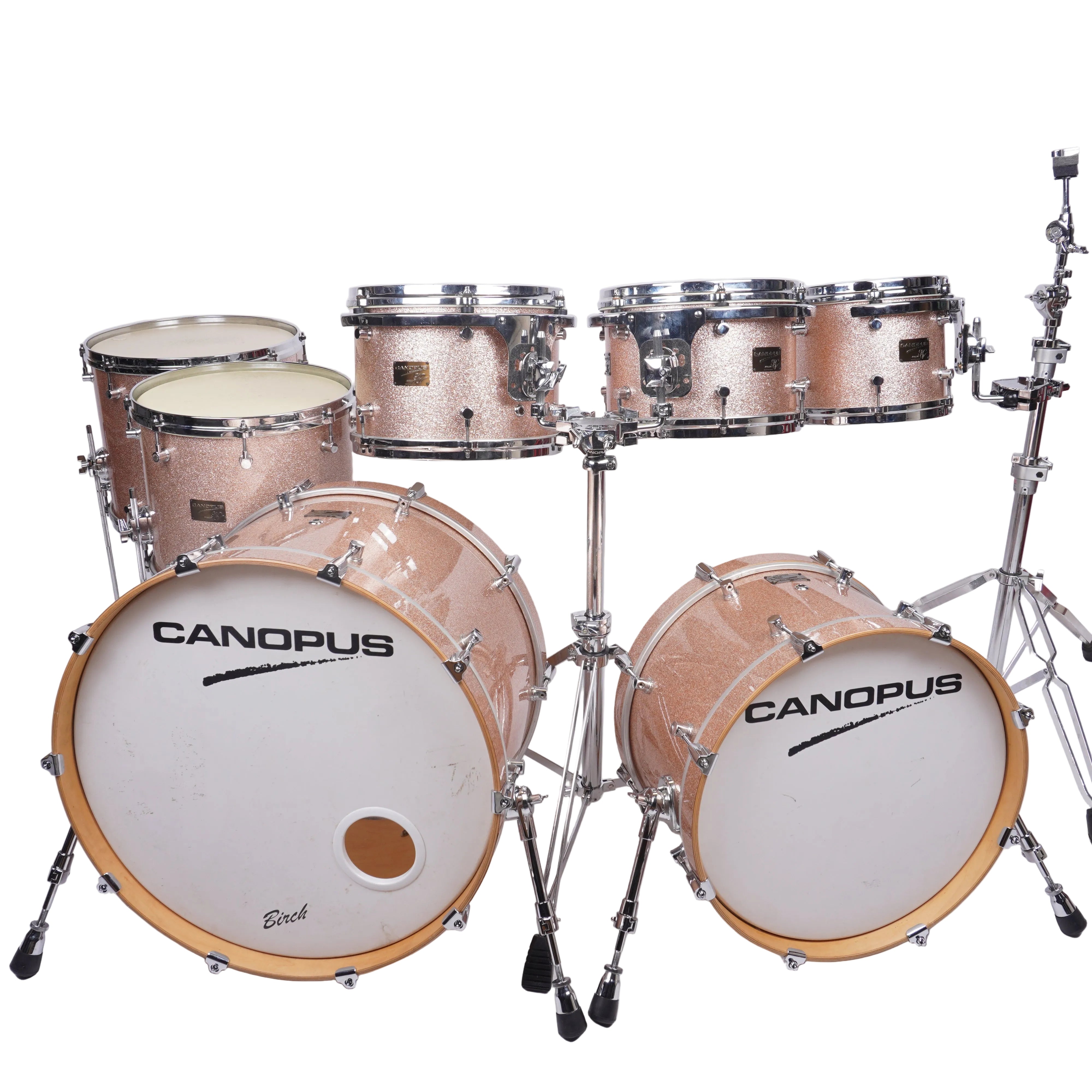 A Canopus drum kit with a glittery rose gold finish, chrome hardware, and white drum heads, photographed against a plain white studio background.
